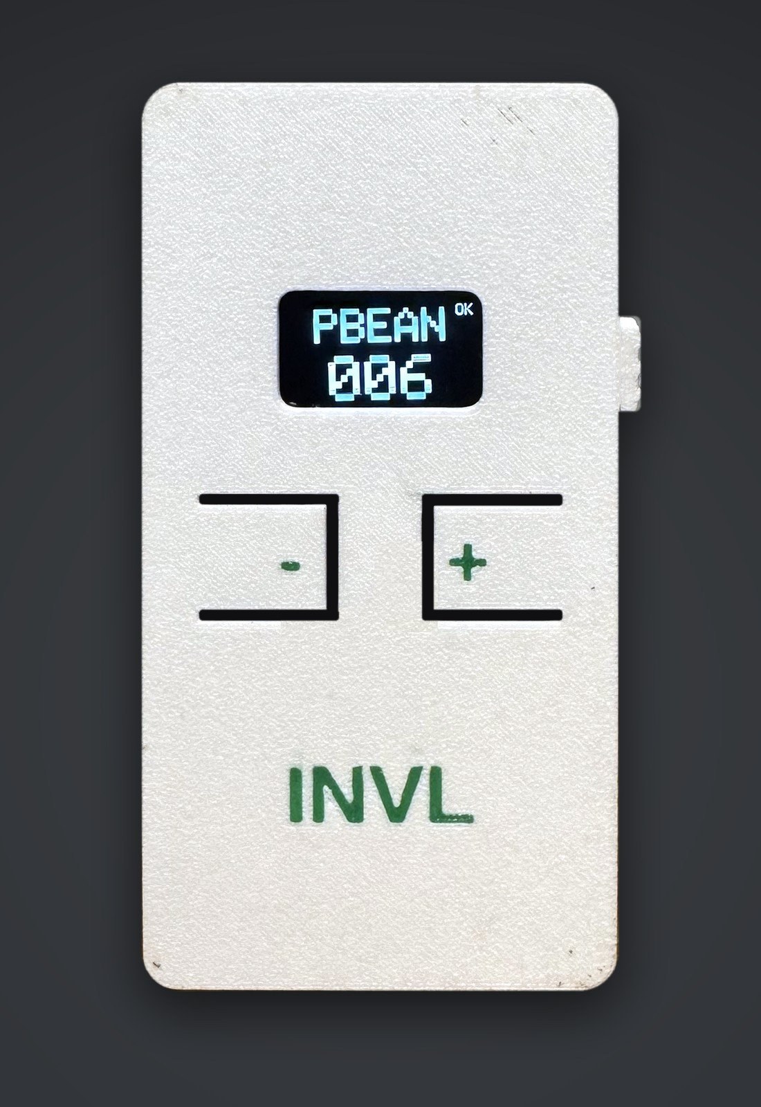 A working INVL counter on a dark studio background. The screen reads PBEAN 006 with an OK status, above the minus and plus buttons and the green INVL wordmark.